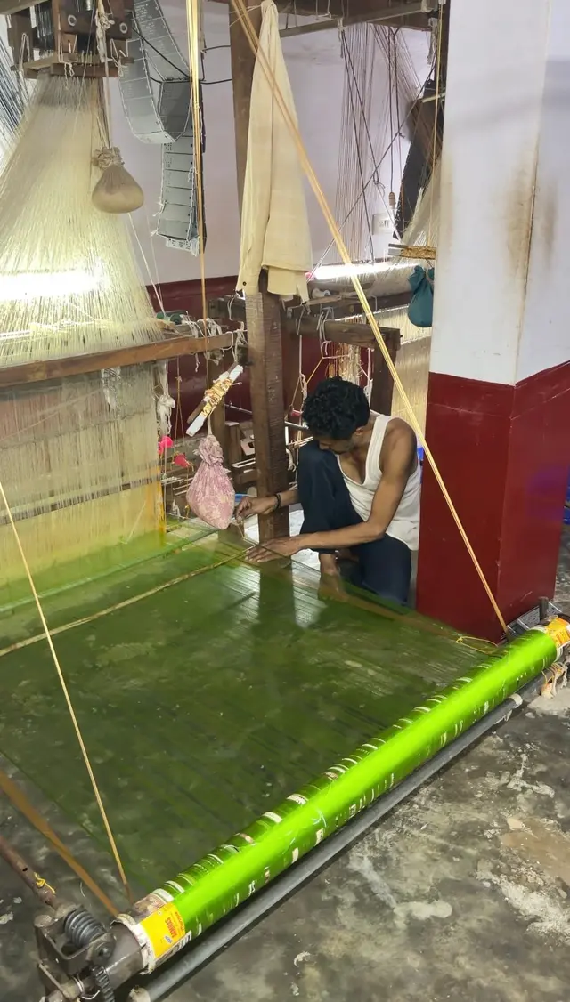 A weaver setting the green silk warp on a handloom